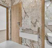 Badezimmer mit hellen Marmorbodenfliesen und eingebautem Hänge-WC in einer 4-Zimmer-Wohnung.