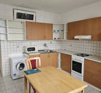 Küche in einer 2-Zimmer-Wohnung mit Küchenzeile, Esstisch und Geräten.
