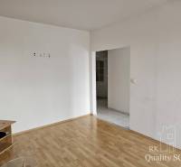 Ein Zimmer in einer 2-Zimmer-Wohnung mit Holzboden und weißen Wänden, mit Möbeln.