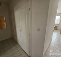 Flur mit hellen Fliesen und weißen Türen in einer Zweizimmerwohnung.
