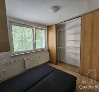 Schlafzimmer in einer 2-Zimmer-Wohnung mit einem großen Einbauschrank und einem Heizkörper unter dem Fenster.