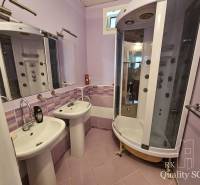 Badezimmer in einer 2-Zimmer-Wohnung mit zwei Waschbecken und einer Hydromassagedusche.
