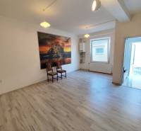 Interieur einer Einzimmerwohnung mit einem Bild an der Wand und zwei Stühlen.