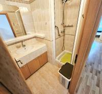 Badezimmer mit Dusche in einer 3-Zimmer-Wohnung, helle Fliesen und Spiegel.