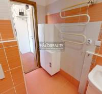 Badezimmer in einer 4-Zimmer-Wohnung mit orangefarbenen Fliesen und einem Handtuchtrockner.