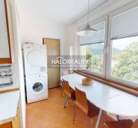 Die Küche in der 4-Zimmer-Wohnung enthält einen Esstisch, Stühle und eine Waschmaschine.