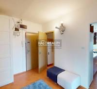 Eingangsflur einer 4-Zimmer-Wohnung mit Verkleidung und einem Raum, der in die Küche führt.