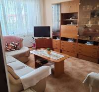 Wohnzimmer mit Sofa, Fernseher und Holzschrank in einer 3-Zimmer-Wohnung.