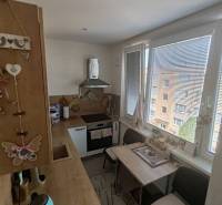 Küche in einer 3-Zimmer-Wohnung mit Holzküche, Esstisch und Geräten.