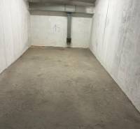 Geschlossener Garagenraum mit Betonboden und weißen Wänden, Nummer 19, Rohre an der Decke.