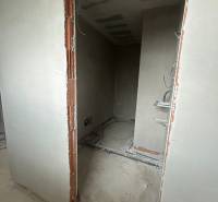 Ein unvollendeter Raum mit Netzen und unverkleideten Ziegeln in einem Einfamilienhaus.