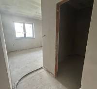 Innenraum eines Einfamilienhauses mit unvollendeten Wänden und offenem Fenster.