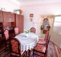 Esszimmer in einem Einfamilienhaus mit antiken Möbeln, einem Blumenmusterteppich und heller Dekoration.