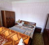 Ein Schlafzimmer in einem Einfamilienhaus mit Bett, Schränken und Bildern an der Wand.