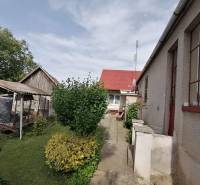 Der Garten des Einfamilienhauses in Hrkovce mit Gehweg, Pavillon und Grünflächen.