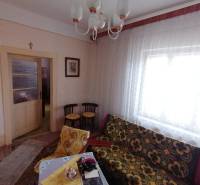 Ein Zimmer mit einem Vintage-Sofa, Möbeln und Vorhängen in einem Einfamilienhaus.