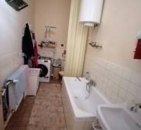 Badezimmer in einem Einfamilienhaus mit Badewanne, Waschbecken und Waschmaschine.