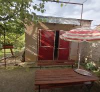 Garten beim Einfamilienhaus in Hrkovce mit Tisch und Sonnenschirm.