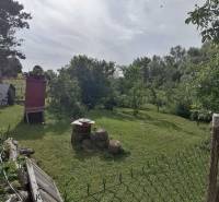 Ein Garten mit Rasen und Bäumen, neben einem Einfamilienhaus in Hrkovce.