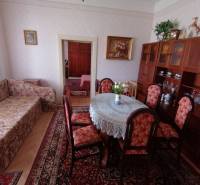 Wohnzimmer in einem Einfamilienhaus mit Sofa, Esstisch und Vitrine.