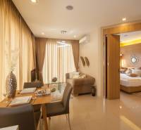 Wohnzimmer und Esszimmer mit Zugang zum Schlafzimmer in einer 2-Zimmer-Wohnung.