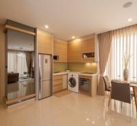 Küchenecke in einer 2-Zimmer-Wohnung, mit Esstisch, Kühlschrank und Waschmaschine.