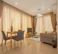 Obývací Zimmer in einer Zweizimmerwohnung mit Esstisch und Sofa.