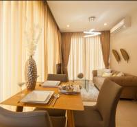 Esszimmer in einer 2-Zimmer-Wohnung mit Holzmöbeln und hängenden Vorhängen.