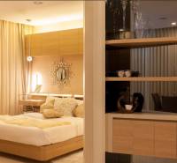 Schlafzimmer in einer 2-Zimmer-Wohnung mit Holzelementen und einem bequemen Bett.