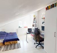 Dachzimmer mit Bett, Schreibtisch und Schrank in einem Einfamilienhaus.