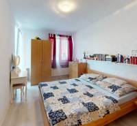 Ein Schlafzimmer in einem Einfamilienhaus mit hellen Wänden, einem Doppelbett, einem Kleiderschrank und einem Schminktisch.