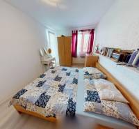 Schlafzimmer im Einfamilienhaus mit Bett, Büchern, Schrank und Spiegel.