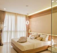 Ein stilvolles Schlafzimmer in einer 3-Zimmer-Wohnung mit transparenten Vorhängen und Holzelementen.
