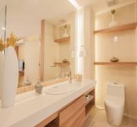 Badezimmer in einer 3-Zimmer-Wohnung mit Waschbecken, Toilette und dekorativen Regalen.
