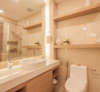 Badezimmer einer 3-Zimmer-Wohnung mit Waschbecken, Spiegel und Toilette.