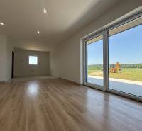 Geräumiges Zimmer mit Laminatboden und großen Glastüren in einem Einfamilienhaus.