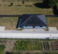 Einfamilienhäuser in Podlužany mit Solarpaneelen, Rasen und Garten.