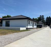 Einfamilienhaus in Podlužany mit weißer Fassade, schrägem Dach und großer Zufahrt.