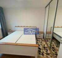 Schlafzimmer in einer 2-Zimmer-Wohnung mit einem Doppelbett und einem Einbauschrank an der Wand.