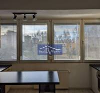 Einzimmerwohnung mit großen Fenstern und Kochnische, mit Blick auf die Stadt.