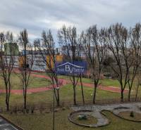 Blick auf das Schulgelände mit Laufbahn und umliegenden Wohnhäusern in Petržalka.