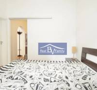 Schlafzimmer mit Doppelbett und gemusterter Bettwäsche in einer 2-Zimmer-Wohnung.