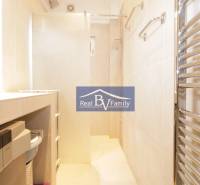 Badezimmer in einer 2-Zimmer-Wohnung mit Waschmaschine, Duschkabine und Handtuchheizkörper.