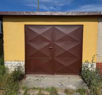 Braune Garage in der Záhradná-Straße in Svit mit Pflanzen rundherum.