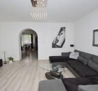 Wohnzimmer in einem Einfamilienhaus mit großer Couch und moderner Einrichtung.