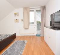 Schlafzimmer in einem Einfamilienhaus mit Bett, Fernseher, Schrank und Zugang zum Balkon.