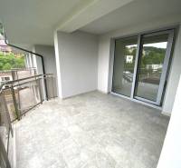 Ein Balkon in einer 2-Zimmer-Wohnung in Rajecké Teplice mit Blick auf das Grün und die umliegenden Gebäude.