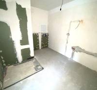 Innenraum einer unvollendeten 2-Zimmer-Wohnung mit vorbereiteten Leitungen an den Wänden.