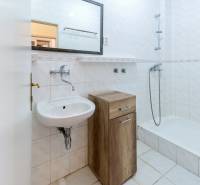 Badezimmer mit Badewanne und Waschbecken in einer 2-Zimmer-Wohnung, einfaches weißes Design.