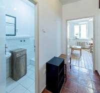 Flur mit Zugang zum Badezimmer und Zimmer in einer 2-Zimmer-Wohnung mit heller Einrichtung.